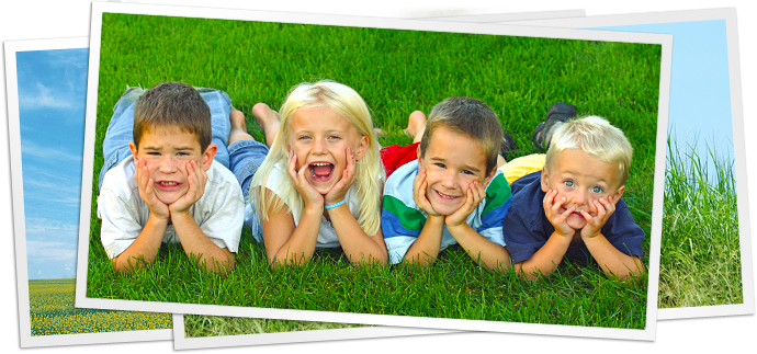 photo of four children laying in grass