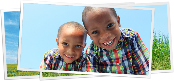 photo of two children leaning over camera